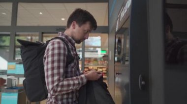 Bir adam Alman süpermarketinde plastik şişeleri iade ediyor. Geri dönüşüm otomatı plastik şişeleri, ekoloji konsepti. Otomatdaki adam depozito şişeleri satıyor, depozito şişeleri topluyor.