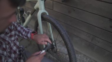 Bisiklet parkında bisikleti tamir eden adam. Almanya 'da lastik pompalayan bir adam. Bisikletçi el aleti kullanıyor, bisiklet pompası. Döngü bozulması ve hızlı onarım 