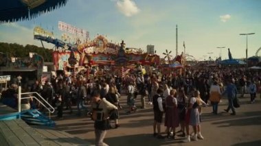 23 Eylül 2022. Münih. Almanya. Oktoberfest. 2022 'de güneşli bir havada Oktoberfest' teki lunapark. Oktoberfest 'teki insanlar. Münih 'te Ekim Festivali. Eğlence parkı mı? # İşte oldu #. 
