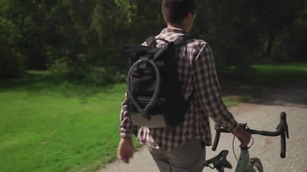在德国 背对背包和自行车锁视图的骑自行车的送信人去推自行车 一个骑自行车上下班的人骑自行车走路 自行车抛锚了 他把它甩在身边 — 图库视频影像