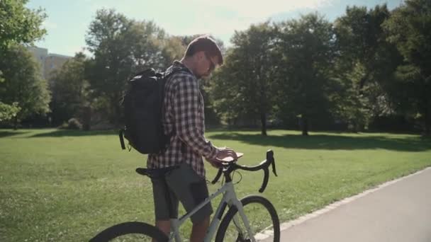 Een Mannetje Loopt Naast Zijn Fiets Gebruikt Een Smartphone Bij — Stockvideo