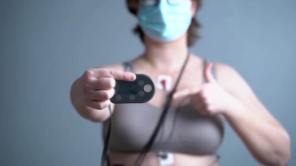 Donna Irriconoscibile Maschera Medica Indossa Holter Monitor Monitoraggio Elettrocardiogramma Giornaliero — Video Stock