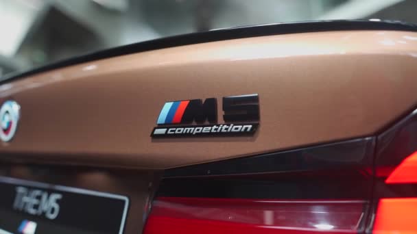 2022年8月20日ドイツ ミュンヘン Bmw M5のロゴは Bmw ウェルト展示センターにあります バイエルンM5シリーズの競争のショールームで金 茶色の車 Mパフォーマンス版 車の外観の詳細 — ストック動画