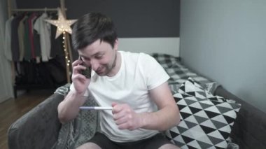 Erkek gebelik testi yaptırıyor ve iyi haberi vermek için arkadaşını arıyor. Baba olacak. Hamile olduğunu söylemek için arayan mutlu bir adam. Biz ebeveyn olacağız. Adam mutlu bir hamilelik geçiriyor.. 