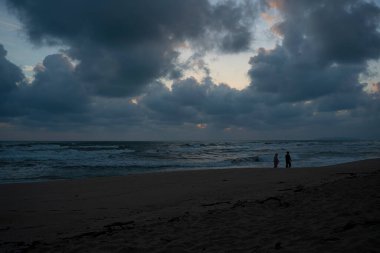 Şafakta yürüyen bir çiftle sahili görmek