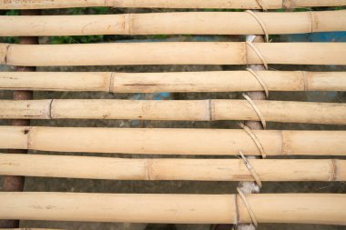 Bambu tahtalar, rattan bir masa oluşturmak için paralel dizilmiş..