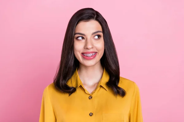 Foto de engraçado morena penteado jovem senhora olhar espaço vazio usar camisa amarela isolada no fundo cor-de-rosa — Fotografia de Stock