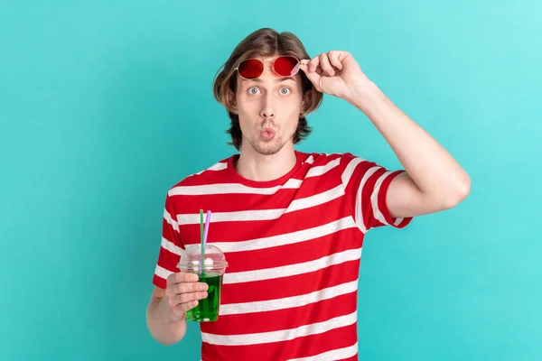 Ritratto di attraente ragazzo funky bere succo piscina partito broncio labbra isolato su luminoso verde acqua colore sfondo — Foto Stock