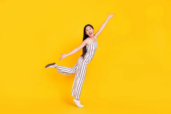 Longitud completa tamaño del cuerpo foto mujer en general riendo alegre con las manos abiertas aislado de color amarillo brillante fondo — Foto de Stock