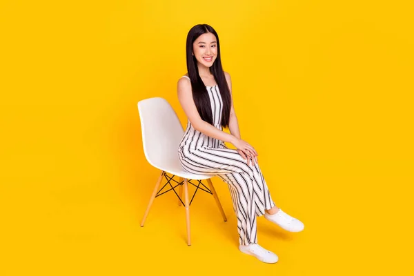 Longitud completa tamaño del cuerpo foto joven sentada en la silla con casual general sonriente aislado vívido color amarillo fondo — Foto de Stock