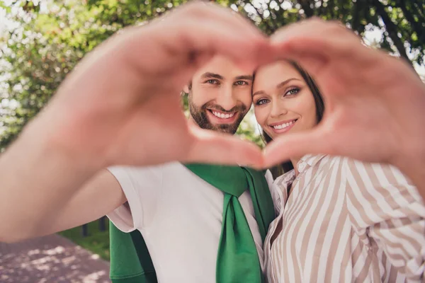 Photo portrait young couple spending time in park sunny weather showing heart sign on date — Stock Photo, Image