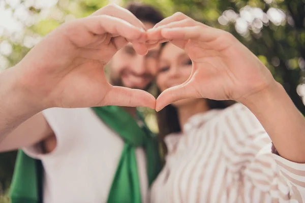 Blurred photo portrait couple spending time in park happy showing heart sign with hands together smiling — Stock Photo, Image