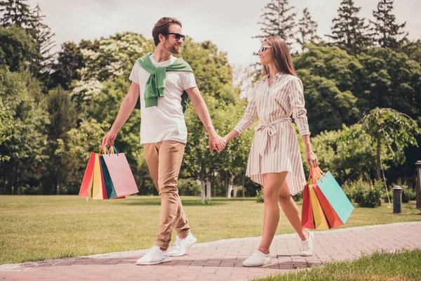 Tamanho total do corpo foto andando casal mantendo sacos depois de fazer compras usando óculos de sol — Fotografia de Stock
