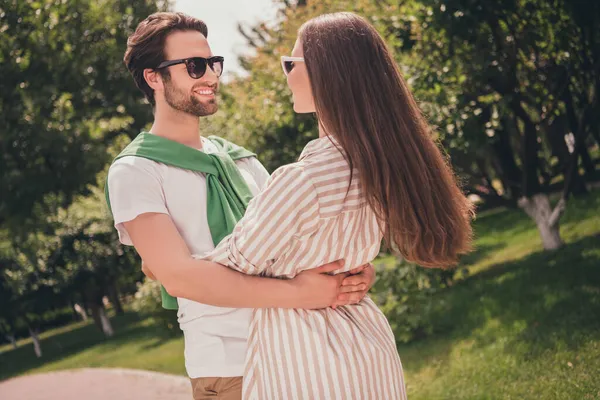 Portret fotograficzny młoda para uśmiecha się przytulając się do siebie spędzając razem czas na zewnątrz w zielonym parku — Zdjęcie stockowe