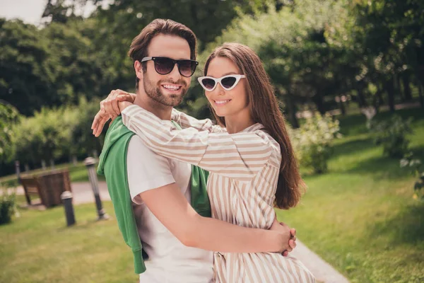 Foto portriat joven pareja sonriendo abrazándose usando gafas de sol ropa casual en tiempo soleado —  Fotos de Stock