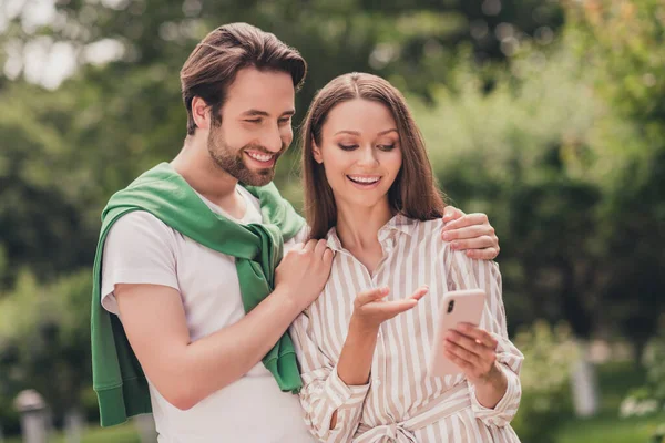 행복 한 미소를 짓고 있는 젊은 커플의 사진은 스마트폰으로 온라인 휴가를 즐기는 모습을 보여준다. — 스톡 사진