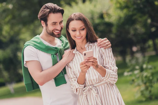 Photo de jeune couple joyeux heureux sourire positif regarder parcourir téléphone portable Voyage vacances marcher à l'extérieur — Photo