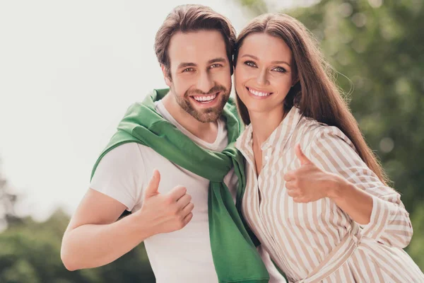 즐거운 젊은 커플 행복 한 미소 포옹 사진, 엄지 손가락들을 보여 주고 좋은 피드백 광고 가 야외에서 선택하는 모습 — 스톡 사진