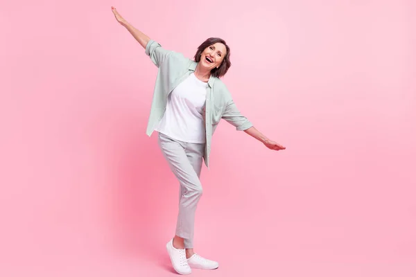 Foto em tamanho completo de positivo animado idade pessoa braços voando têm bom humor isolado no fundo cor-de-rosa — Fotografia de Stock