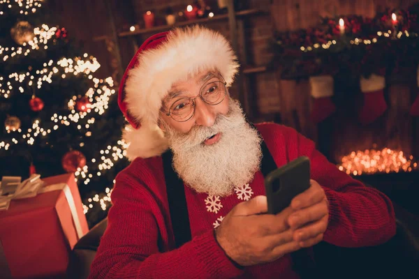 照片上可笑的兴奋年龄的圣诞老人身穿红色服装打字现代装置微笑在室内房间里 — 图库照片