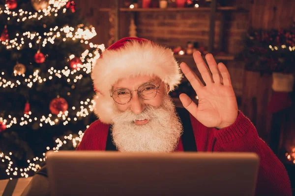 Портрет привлекательного веселый Санта с помощью ноутбука делает видеозвонок размахивая привет поздравления на дому лофт промышленного интерьера в помещении — стоковое фото