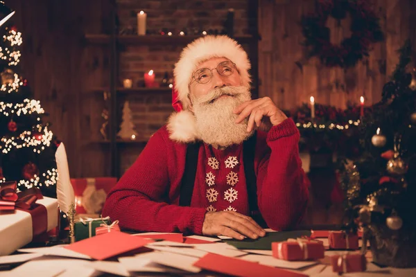 Photo of aged Santa Claus szczęśliwy pozytywny uśmiech ręka dotknąć brody myśleć marzenie cieszyć się wieczorny czas noel dekoracji atmosfera wewnątrz — Zdjęcie stockowe