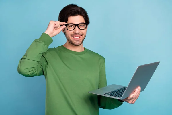 Zdjęcie młodego mądrego uśmiechniętego biznesmena kujona pracującego w laptopie nowy projekt izolowany na niebieskim tle koloru — Zdjęcie stockowe