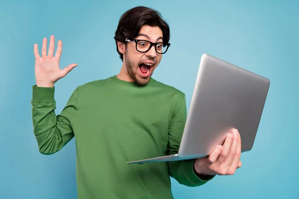 Portré fiatal izgatott őrült vidám fickó szemüvegben sikoly diadal győzelem segítségével laptop elszigetelt kék színű háttér — Stock Fotó
