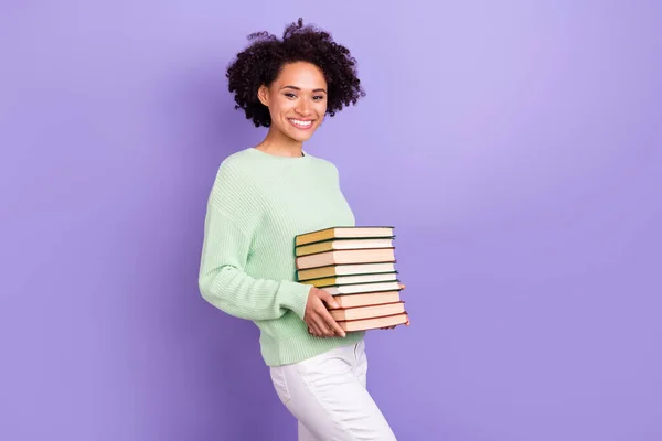 Foto de alegre feliz alegre piel oscura mujer sonrisa buen humor tomarse de la mano libros aislados sobre fondo de color púrpura —  Fotos de Stock