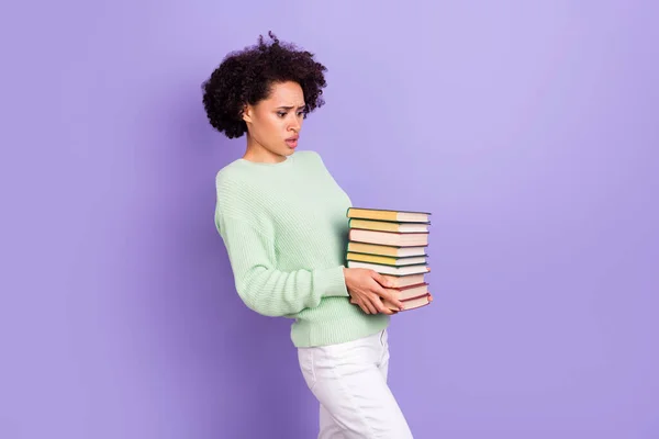 Foto de joven infeliz disgustada piel oscura mujer triste cogida de la mano libros mal humor pesado aislado sobre fondo de color púrpura —  Fotos de Stock