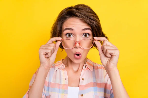 Fotografie ohromený mladá žena reakce informace nosit brýle novinky izolované na žlutém pozadí — Stock fotografie