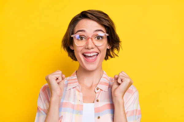 Foto van verbaasd geschokt gelukkig jonge vrouw verhogen vuisten winnaar koele slijtage bril geïsoleerd op gele kleur achtergrond — Stockfoto