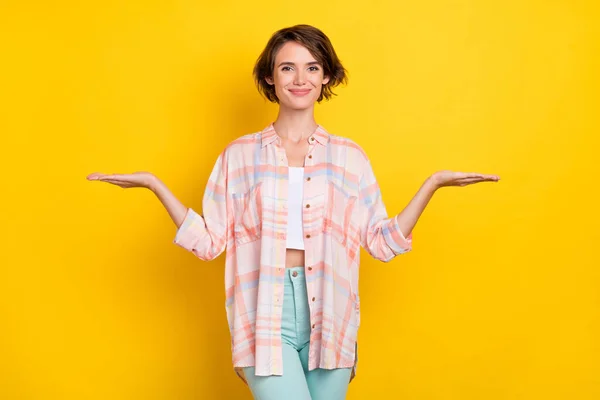 Porträtt av attraktiv glad flicka som håller i handflatorna kopiera tomt utrymme annons isolerad över levande gul färg bakgrund — Stockfoto