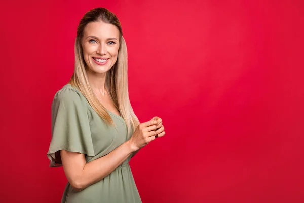 사랑 스러운 젊은 금발 여자의 프로필 사진은 붉은 배경에 고립된 카키색 드레스를 입도록 권장 한다 — 스톡 사진