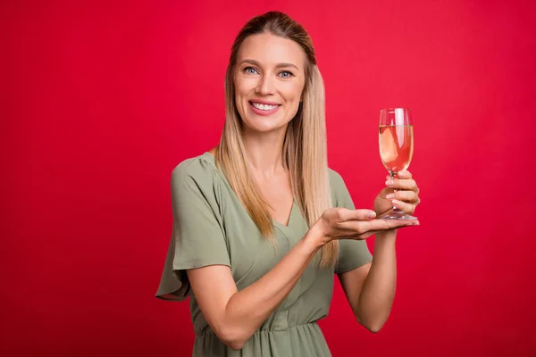 Photo optimiste femme blonde mature index champagne porter robe kaki isolé sur fond de couleur rouge — Photo