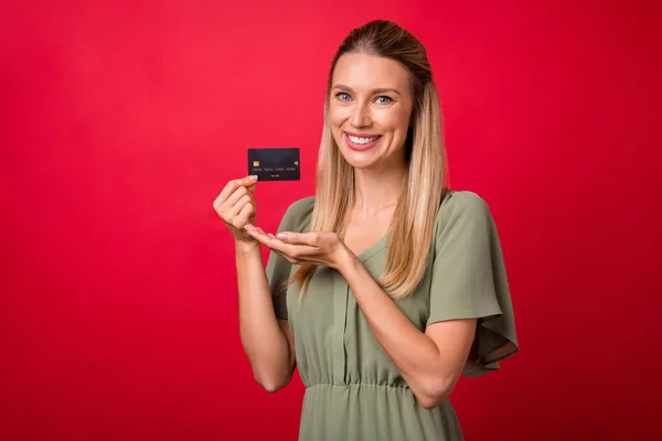 Foto de señora rubia madura indican uso de tarjeta vestido de color caqui aislado sobre fondo de color rojo —  Fotos de Stock