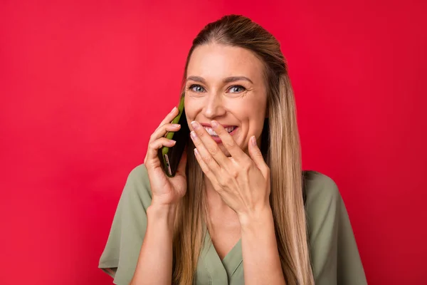 Foto di stupito giovane signora bionda parlano telefono usura camicetta kaki isolato su sfondo di colore rosso — Foto Stock