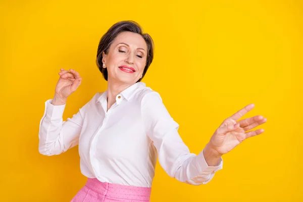 Foto de doce adorável idade mulher vestida camisa branca sorridente dançando olhos fechados isolado cor amarela fundo — Fotografia de Stock