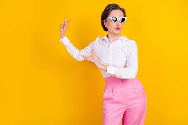 Foto wanita bisnis lanjut usia tersenyum positif mengenakan pakaian glamor yang terisolasi dari latar belakang warna kuning — Stok Foto