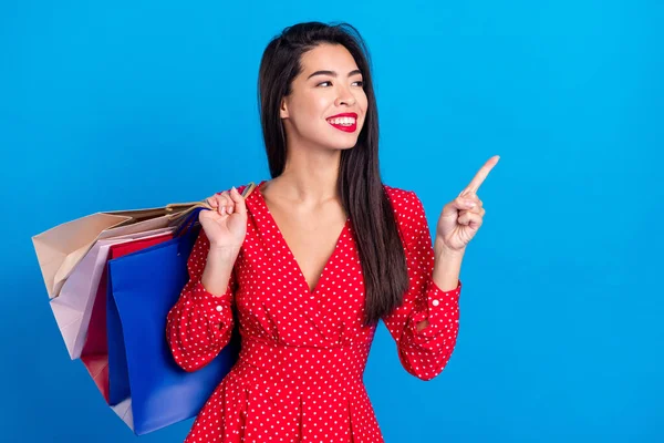 Fénykép portré a nő tartja csomagok bevásárló központ mutatja copyspace ujjal elszigetelt élénk kék háttér — Stock Fotó