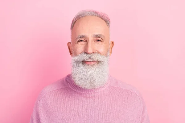 รูปภาพของชายสูงอายุผมสีเทาที่มีความสุขสวมเสื้อสเวตเตอร์สีชมพูแยกจากพื้นหลังสีพาสเทล — ภาพถ่ายสต็อก