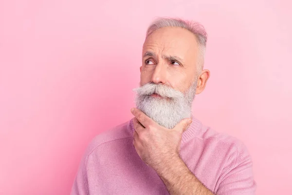 Foto de cabello gris serio envejecido hombre mirada espacio vacío desgaste suéter rosa aislado sobre fondo de color pastel — Foto de Stock