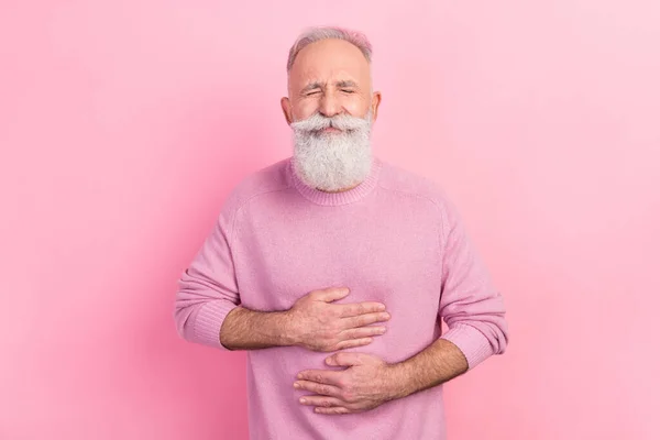Фото грустных седых волос пожилых мужчин руки желудка носить розовый свитер изолированы на пастельном фоне цвета — стоковое фото