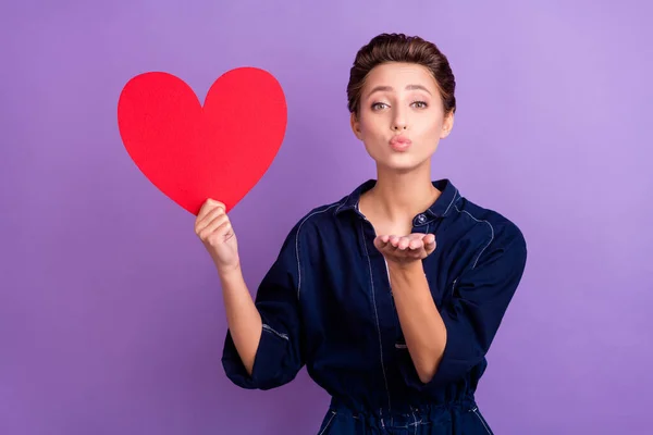 Foto de jovem bela menina positiva enviar-lhe beijo de ar segurar papel vermelho coração dia dos namorados isolado no fundo de cor roxa — Fotografia de Stock