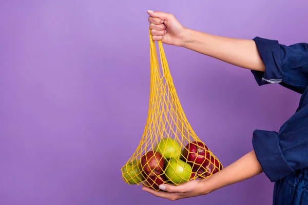 Beskuren bild av kvinna reklam rekommenderar återanvändbar noll avfall shoppingväska isolerad på violett färg bakgrund — Stockfoto