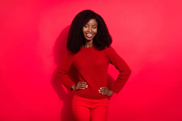 Fotografie sladké sebevědomé tmavé kůže žena oblečená ležérní svetr paže pas úsměv izolované červené barvy pozadí — Stock fotografie