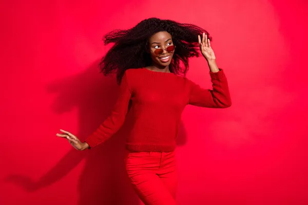 Genç heyecanlı afro kız mutlu pozitif gülümseme boş uzay rüzgarı esintisi kırmızı arka planda izole görünüyor — Stok fotoğraf