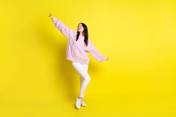 Corpo inteiro foto de milenar marrom penteado senhora dança desgaste rosa camisola calças tênis isolado no fundo de cor amarela — Fotografia de Stock