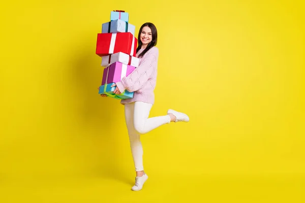 Teljes méretű profil fotó hölgy tartja sok ajándék viselni pulóver fehér nadrág elszigetelt élénk sárga színű háttér — Stock Fotó