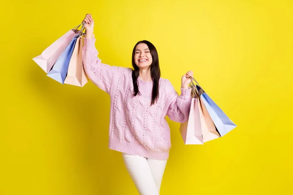 Zdjęcie słodkie millenium pani trzyma torby miłość zakupy nosić sweter izolowany na żółtym tle kolor — Zdjęcie stockowe